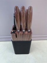 Home & Beyond Co kitchenware knife set with multiple stainless steel blades and ergonomic handles on a wooden countertop.