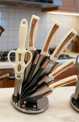 Home & Beyond Co kitchenware knife set with stainless steel blades and black handles, displayed on a wooden kitchen countertop.
